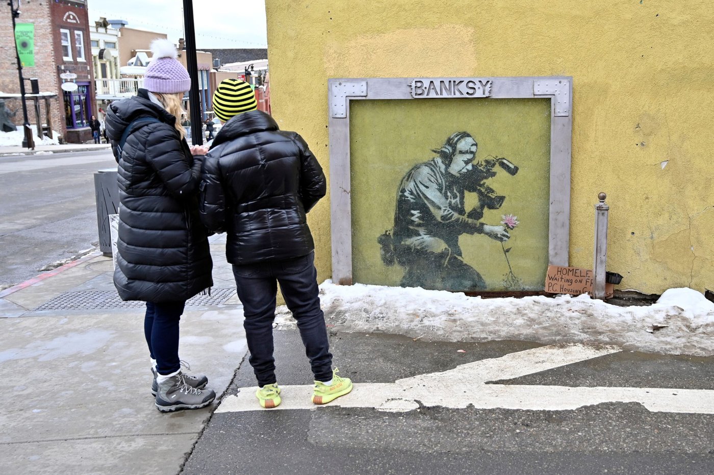 Park City, Utah – January 23: Two women admire graffiti artist Banksy's artwork along Main Street during the Sundance Film Festival, Park City, Utah. (Photo: David Becker / Getty Images)