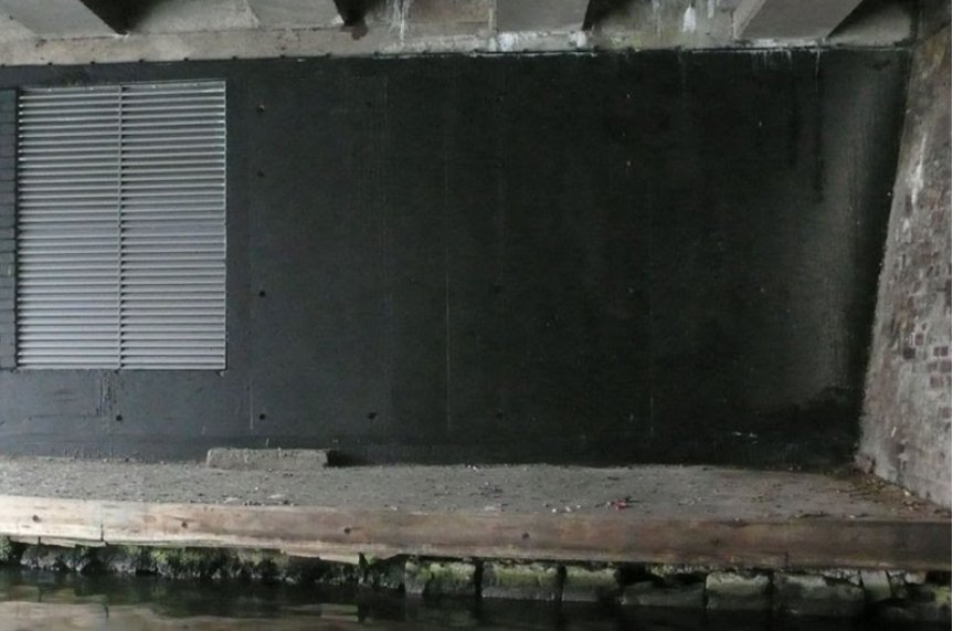 The wall is painted black, presumably by the council — or someone who objects to two grown men acting like children