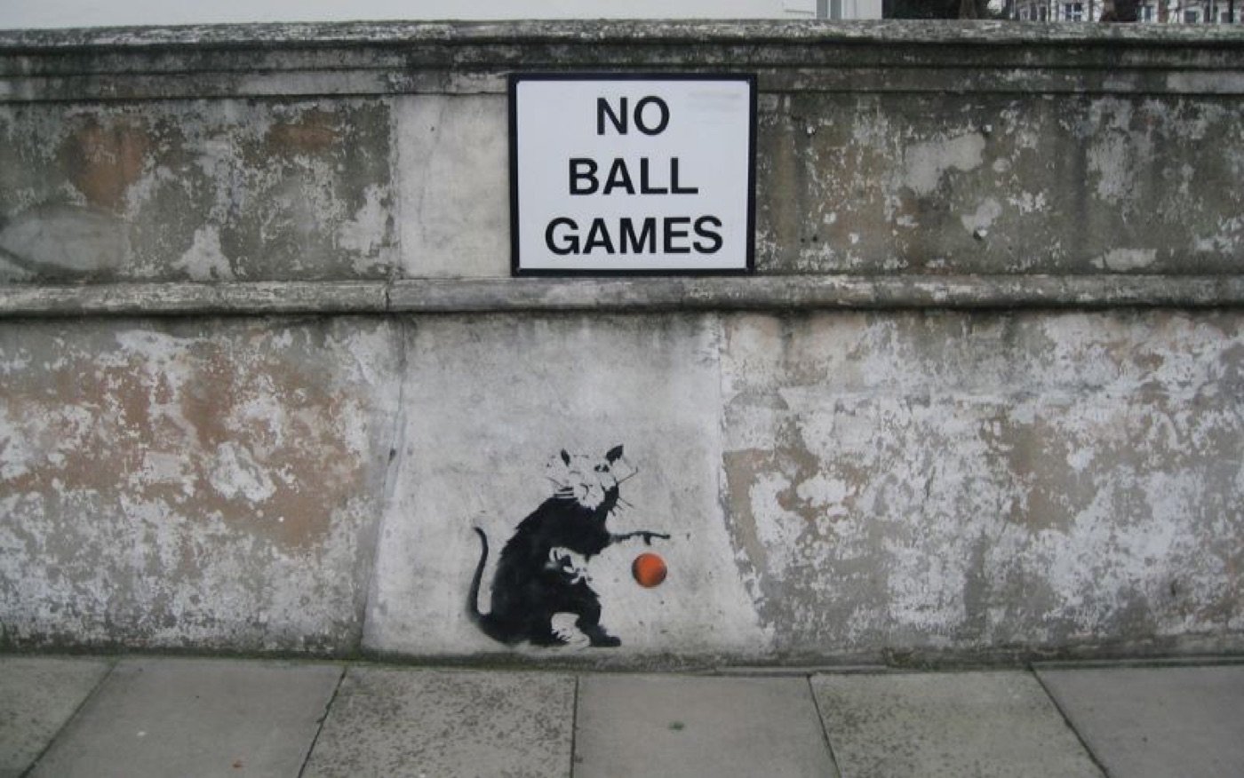 A related street work: a rat playing with a ball beneath a NO BALL GAMES notice.